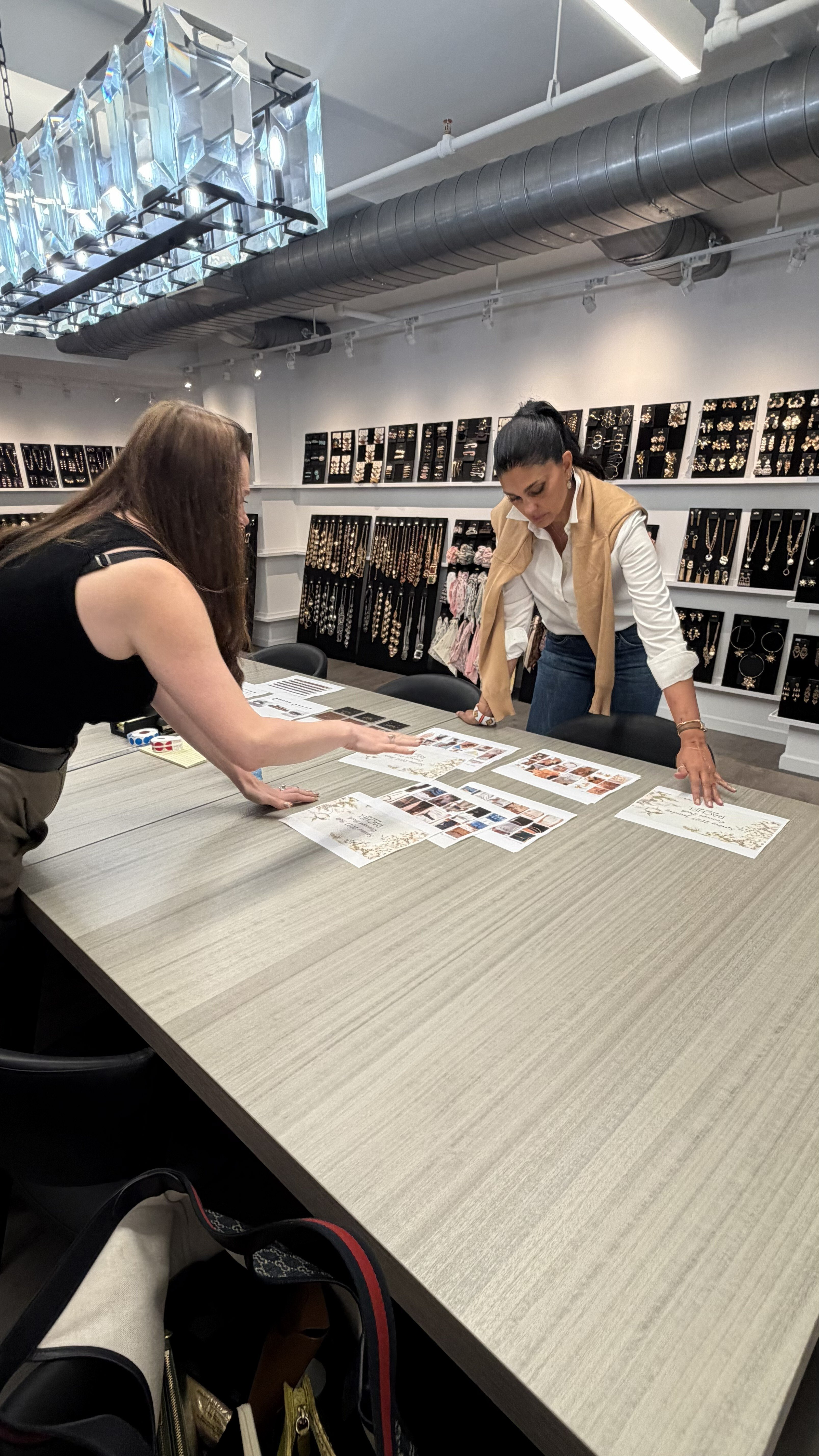 Rachel of Rachel Rachel Roy Reviews Materials across a Table with Active Brand Partners